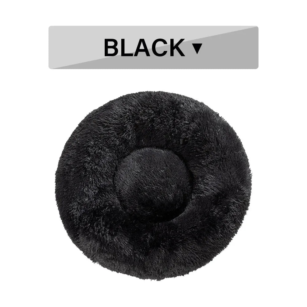 Fluffy donut-shaped dog bed in long plush material, shown in a light grey colour with a raised edge.
