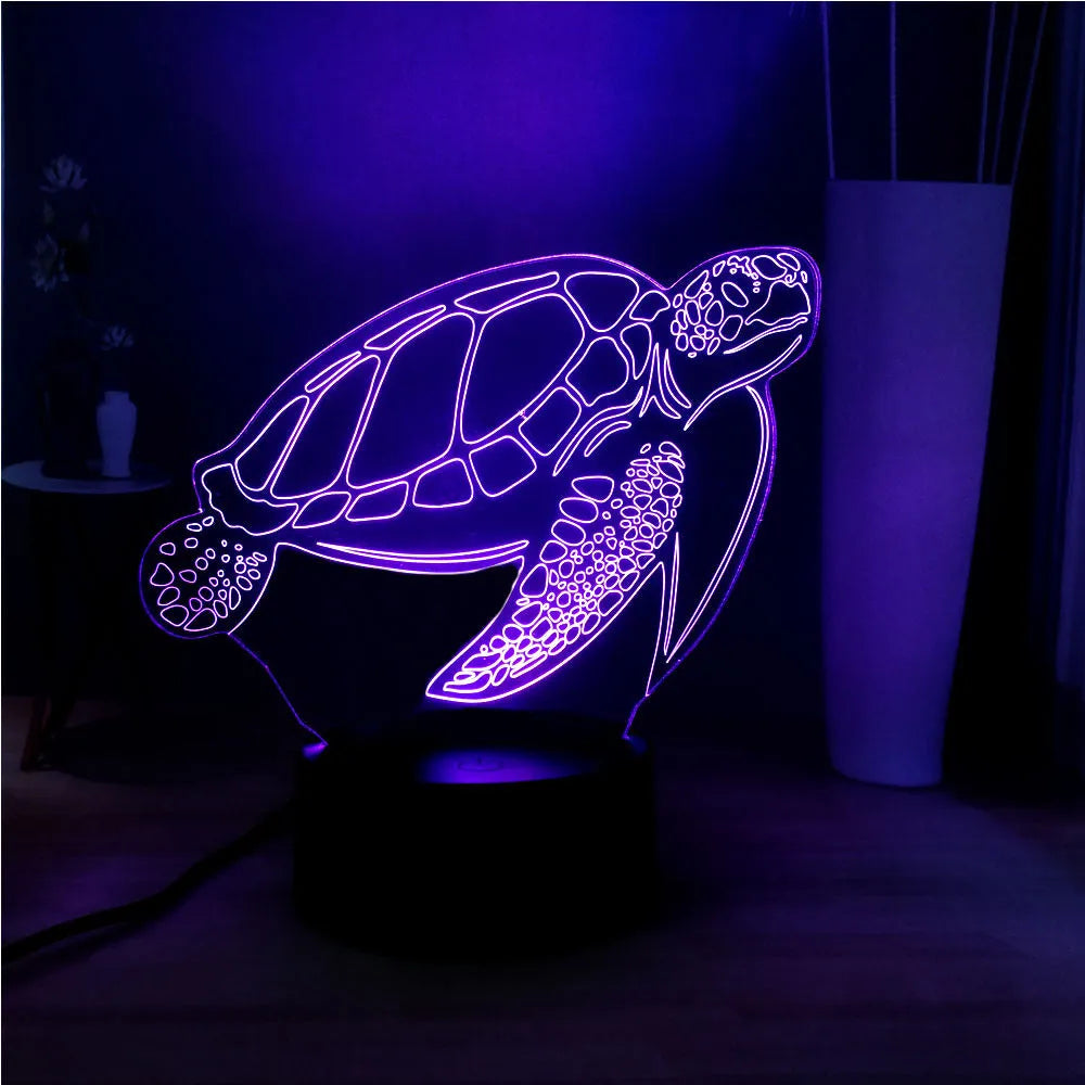 3D acrylic turtle-shaped LED night light with colour-changing modes on a table.