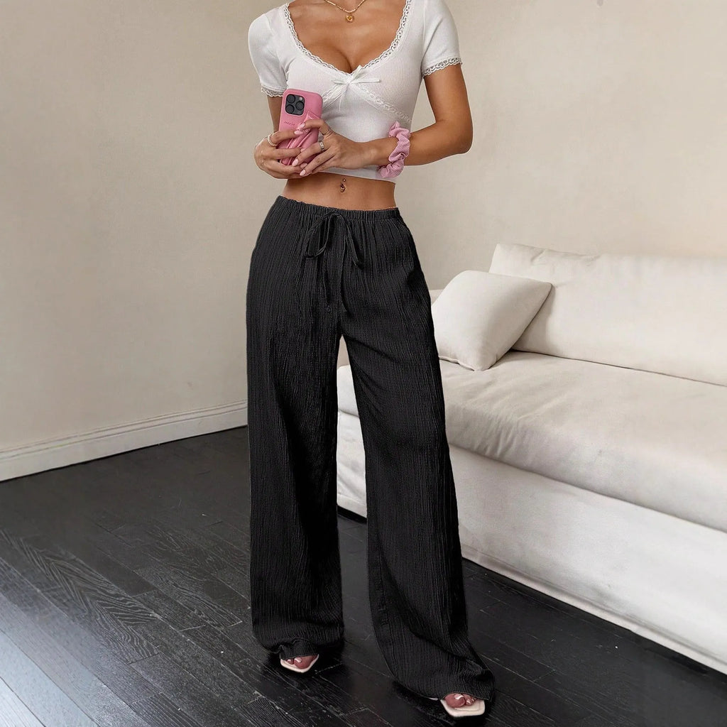 Women's black wide leg trousers with lace-up waist detail, shown with pink colour option