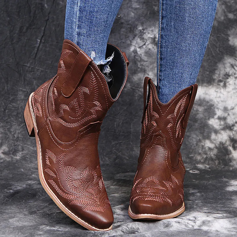Blue women's cowboy boots with floral embroidery, a wedge heel, and a pointed toe.