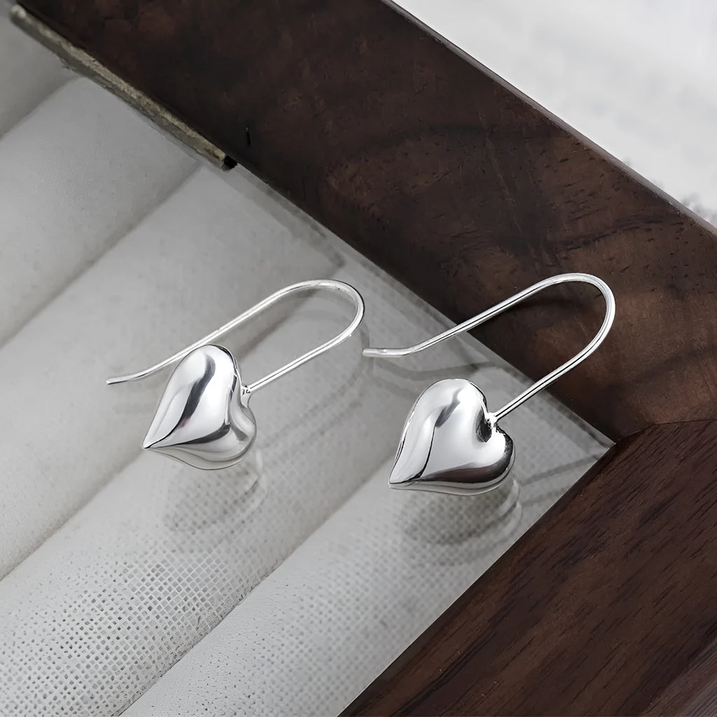 Silver tone heart-shaped earrings with glossy finish and Korean style design