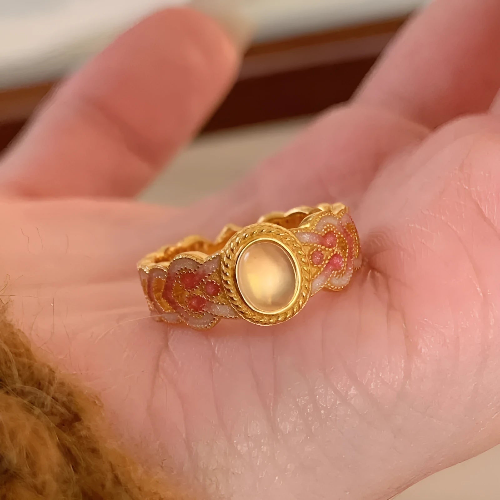 Women's geometric open ring with pink crystal enamel detail on gold-plated copper.