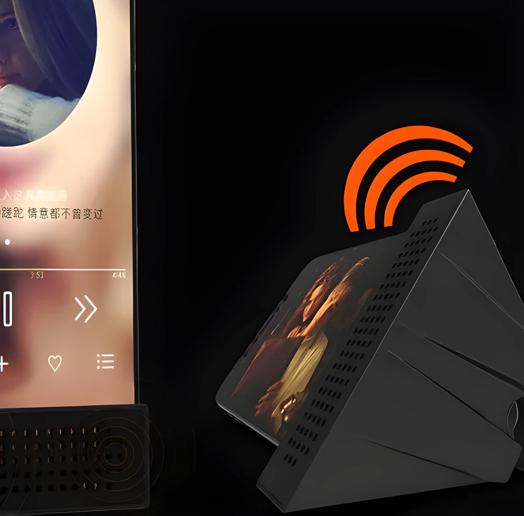 A portable black ABS plastic phone amplifier holder on a desktop, showing a mobile phone inserted for sound amplification.
