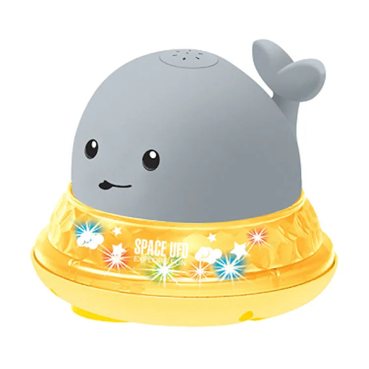 Whale-shaped electric bath toy spraying water with flashing lights, on a blue base.
