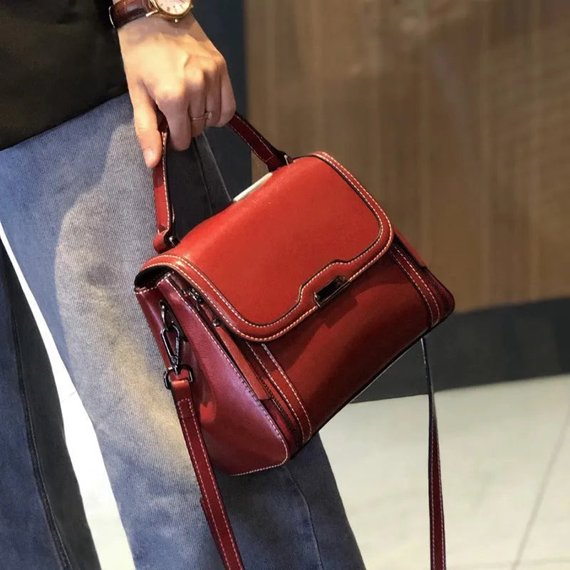 Women's brown genuine leather retro messenger bag with shoulder strap showing organised interior pockets.