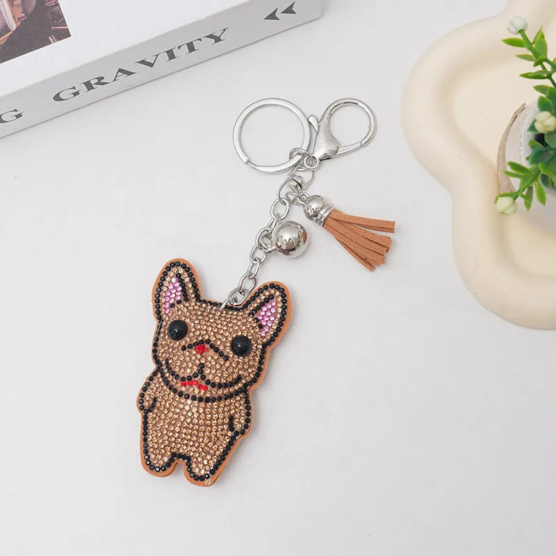 Close-up of a cartoon dog rhinestone keychain charm in alloy, showing sparkling details on a grey background.