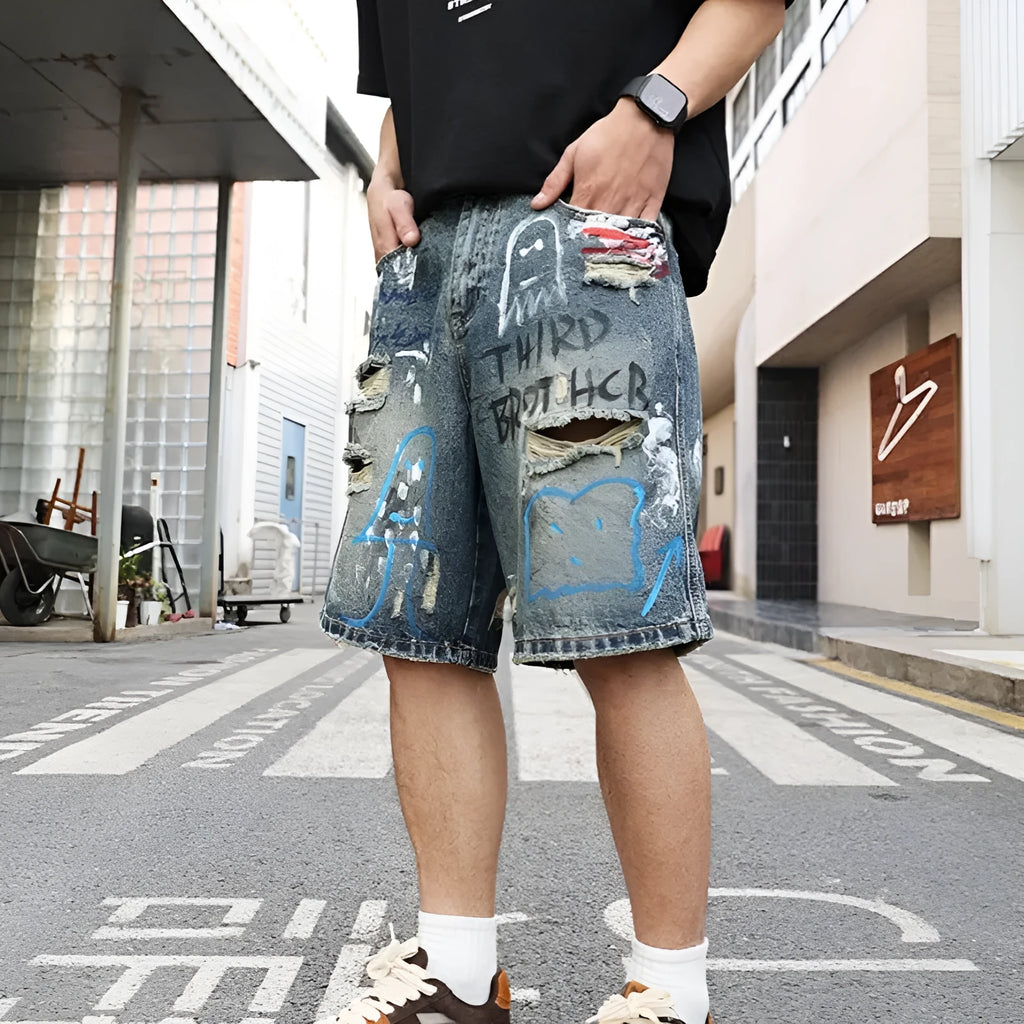 Blue ripped men's denim jeans shorts with a zip fly and straight-leg opening.