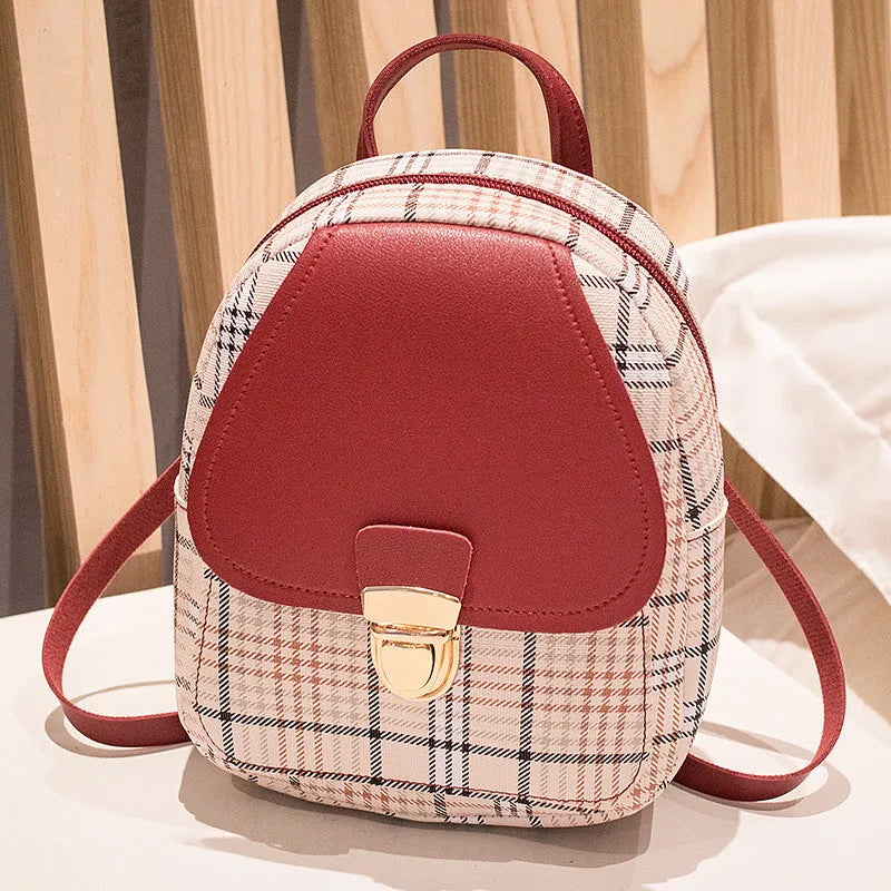 A black one shoulder diagonal phone bag made from PU fabric, shown being worn.