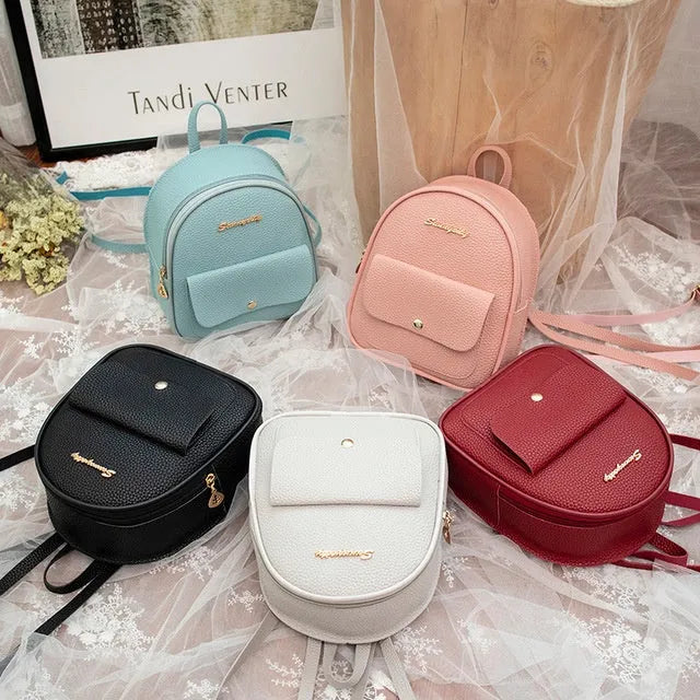Small black PU shoulder backpack for women with zipper, shown next to a mobile phone for scale.