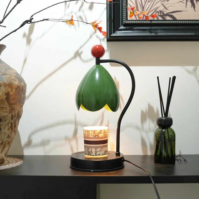 Linglan ancient style melting wax fragrance lamp on a desk, available in cream white or dark green.