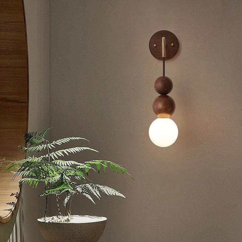 Walnut and copper suspension wall lamp with tri-colour light on a wall