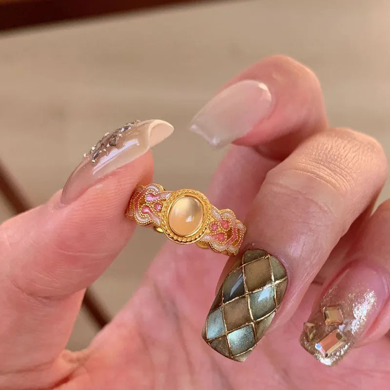 Women's geometric open ring with pink crystal enamel detail on gold-plated copper.