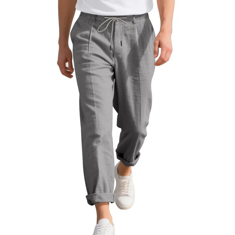 Men's loose-fit straight-leg linen trousers in light khaki colour with a drawstring waist.