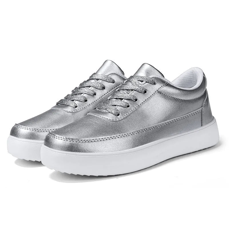 Women's white leather lace-up casual flat trainers on a plain background.