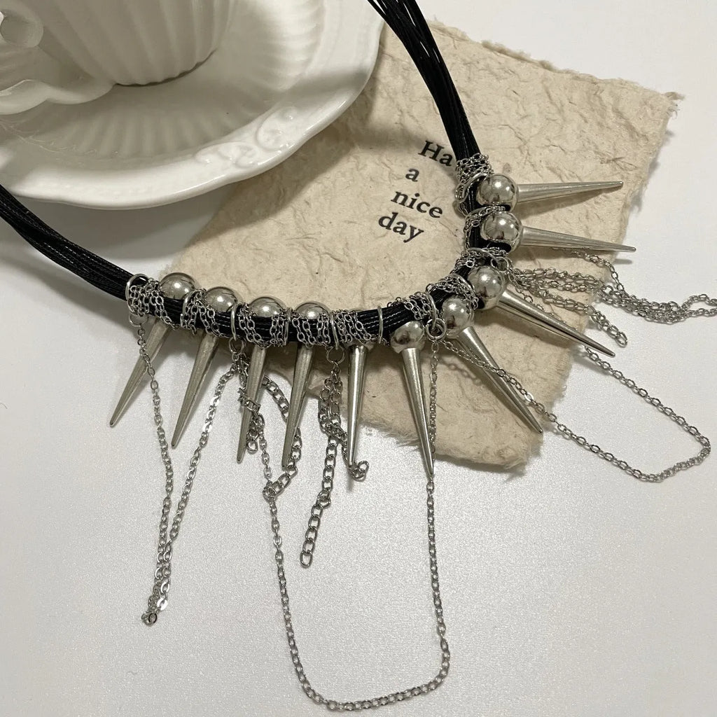 Close-up of a women's casual necklace with leather cord, electroplated round beads, and point rivets in a winding tassel design.