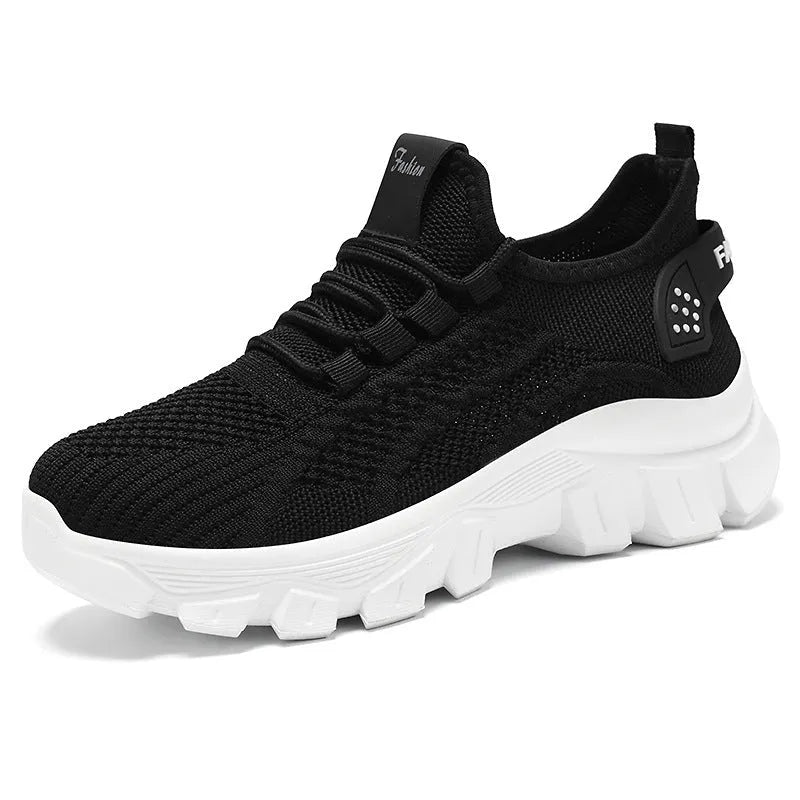 Women's white Flyknit sneaker with thick sole and lace-up front, shown on a neutral background