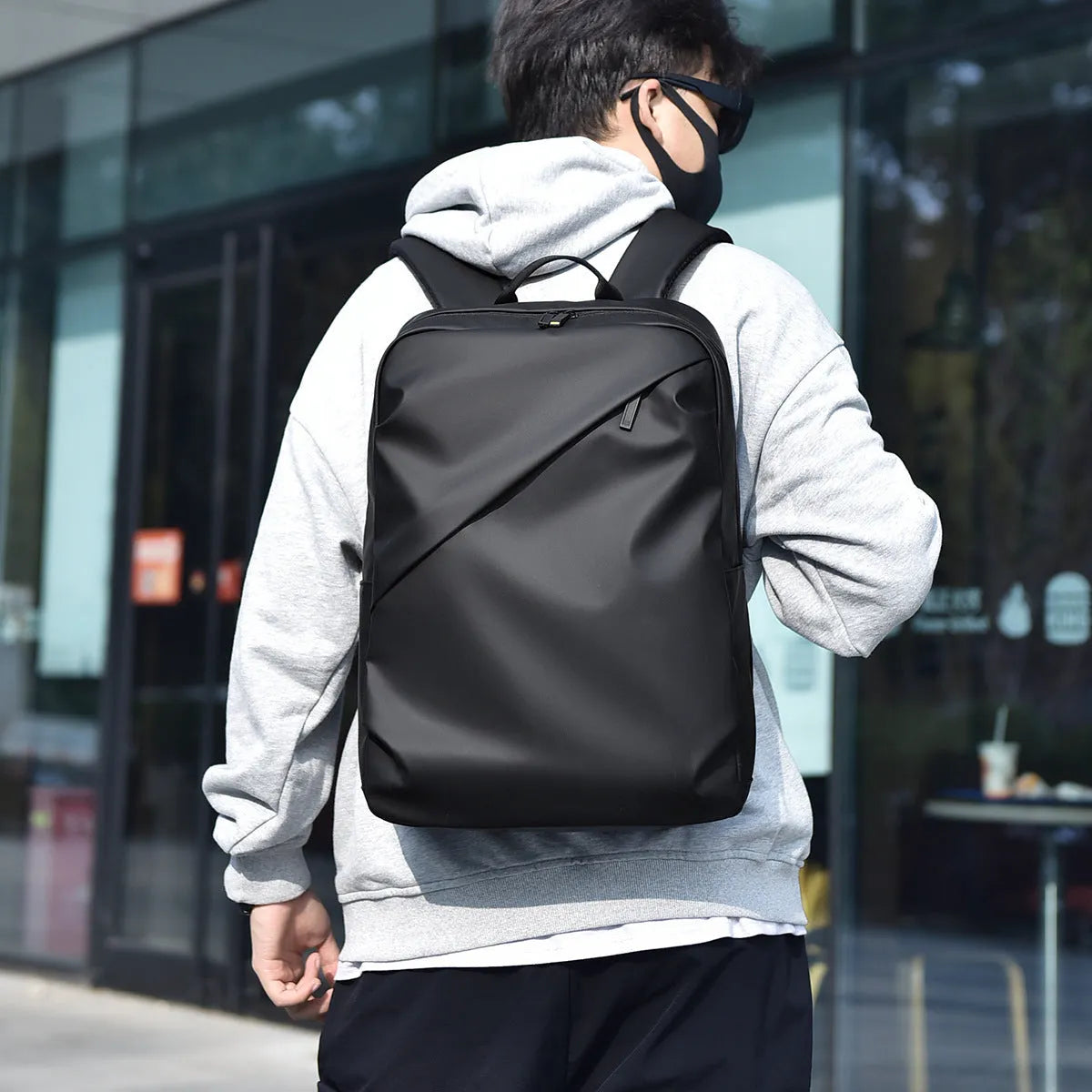 Waterproof laptop backpack in black showing large main compartment and simple design with sewing thread detailing
