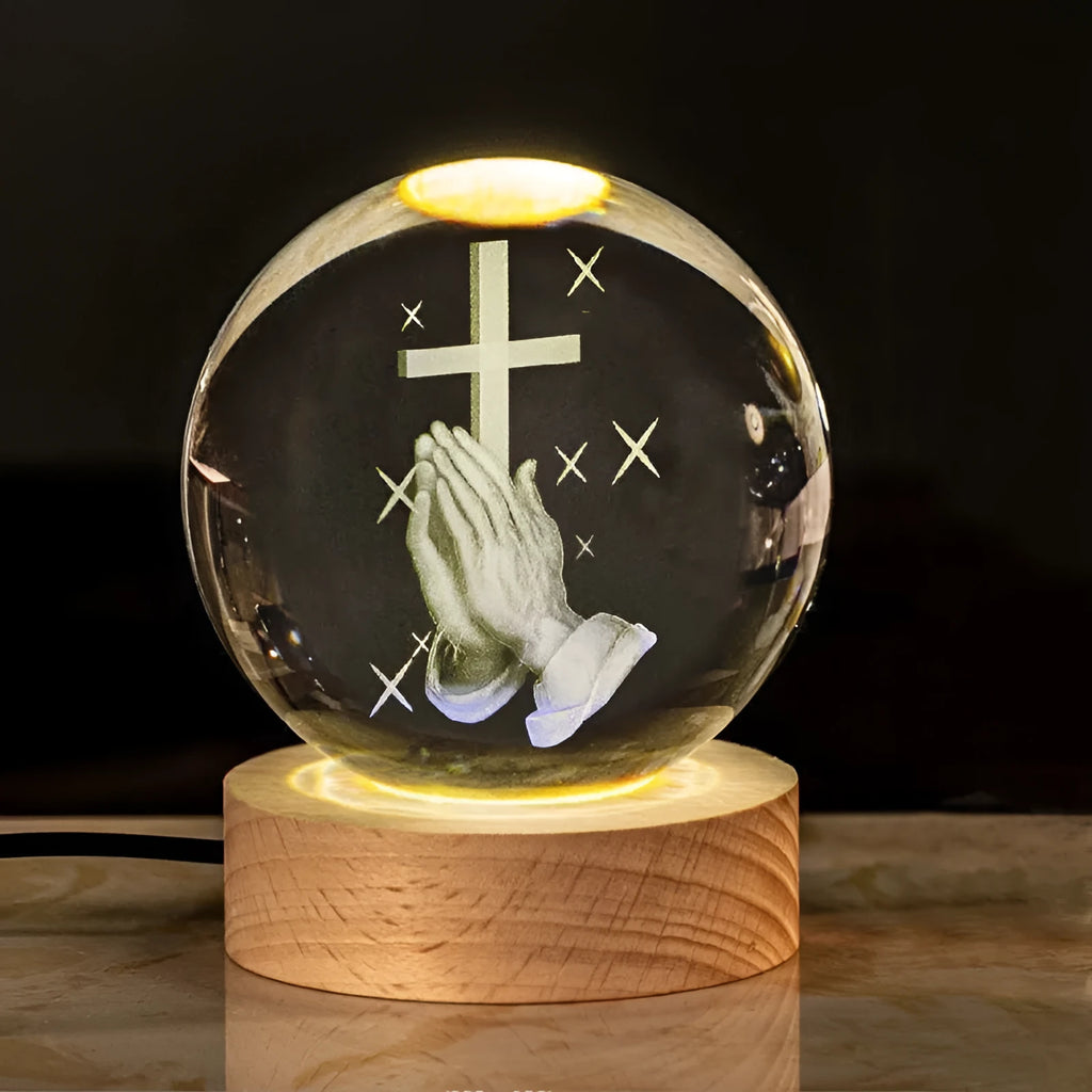 White crystal ball ornament with wood base and warm light, showing detailed internal design.