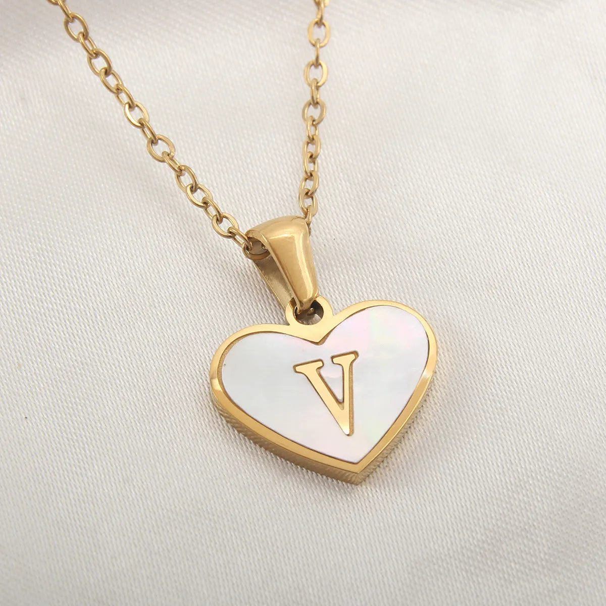 Gold plated heart-shaped personalised necklace with white shell charm on an adjustable chain.