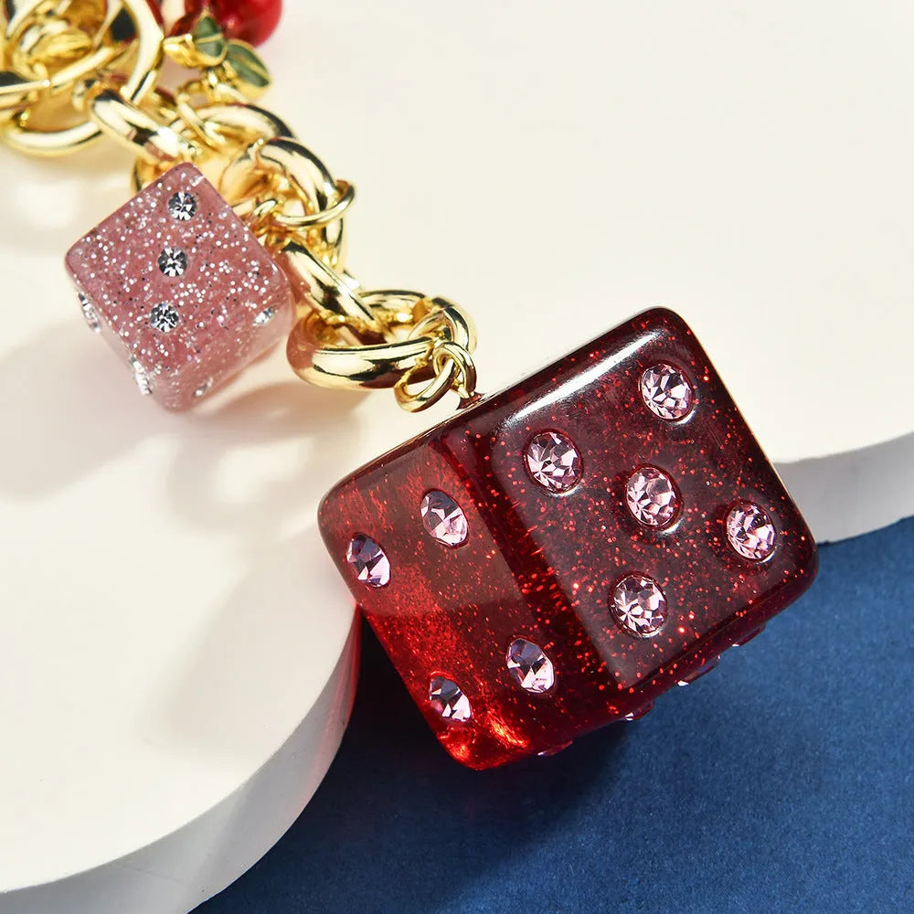 Vintage cherry red two-tone dice pendant on a metal keychain, a retro suitcase ornament.