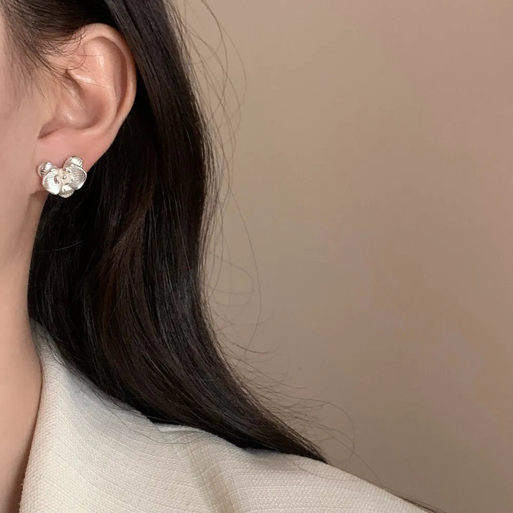 A pair of retro-style copper flower earrings with petal details in a gold electroplated finish.