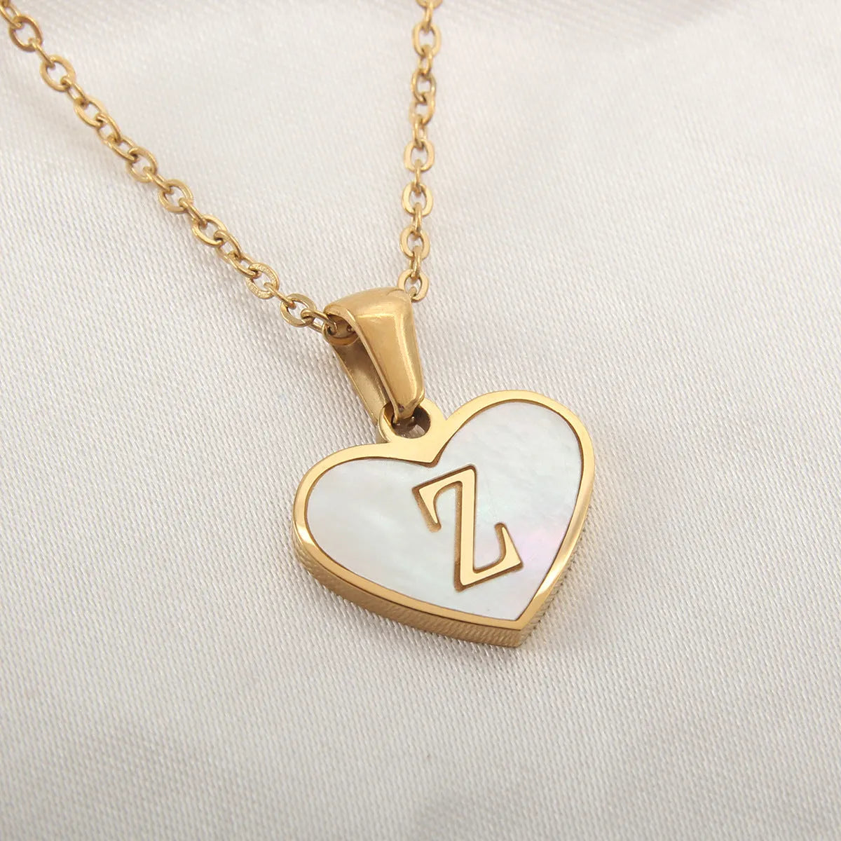 Gold plated heart-shaped personalised necklace with white shell charm on an adjustable chain.