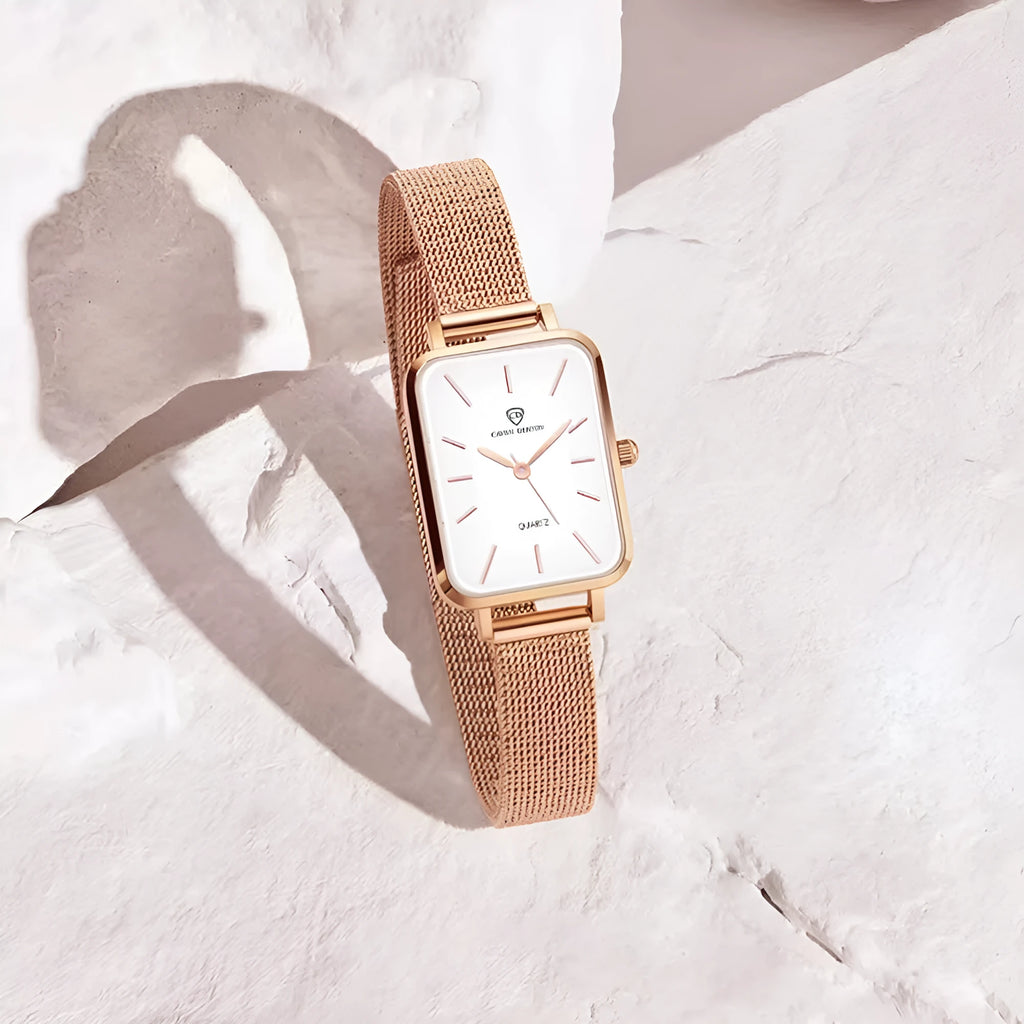 Women's rose gold waterproof quartz watch with woven steel band on wrist.