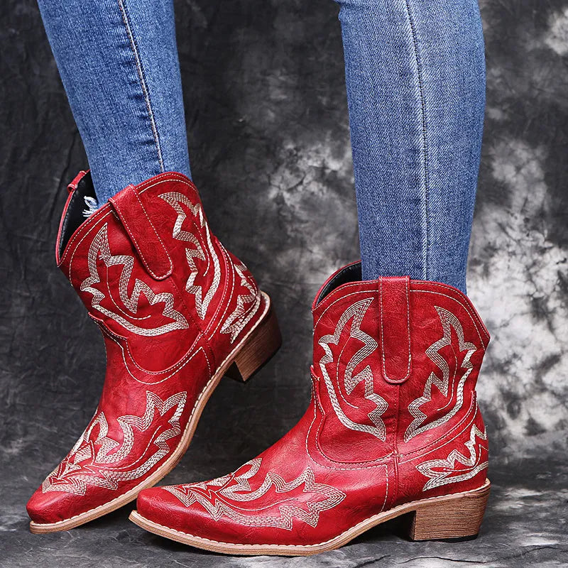 Blue women's cowboy boots with floral embroidery, a wedge heel, and a pointed toe.