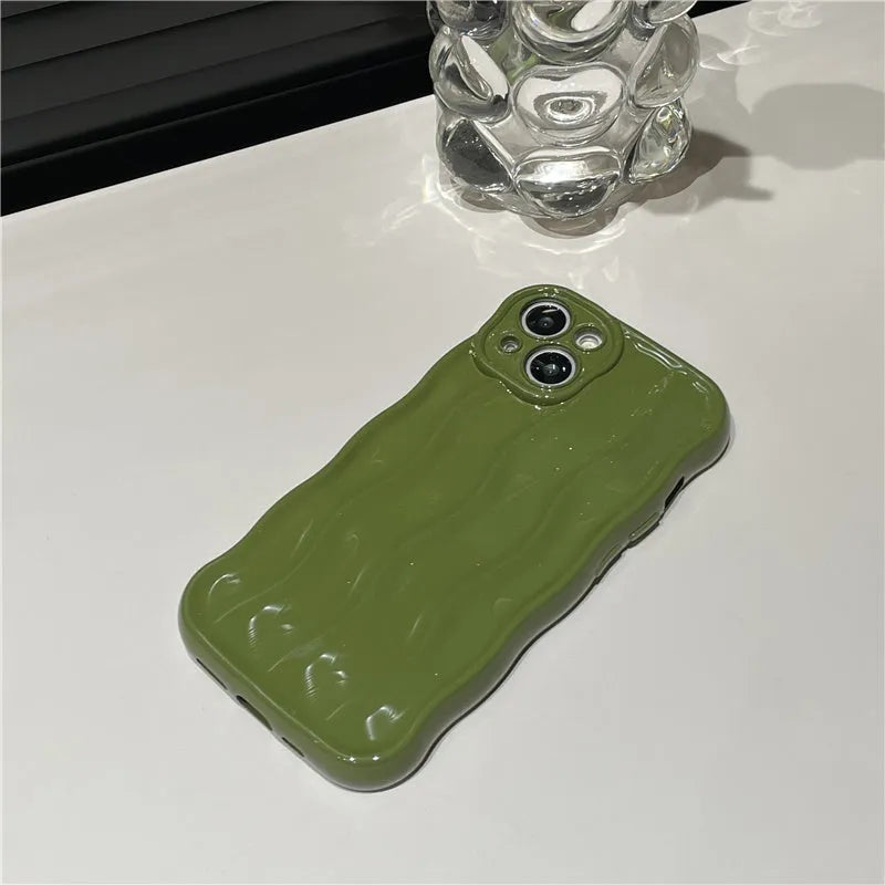 Silicone iPhone case with water ripple texture in green, shown on an iPhone 17 model