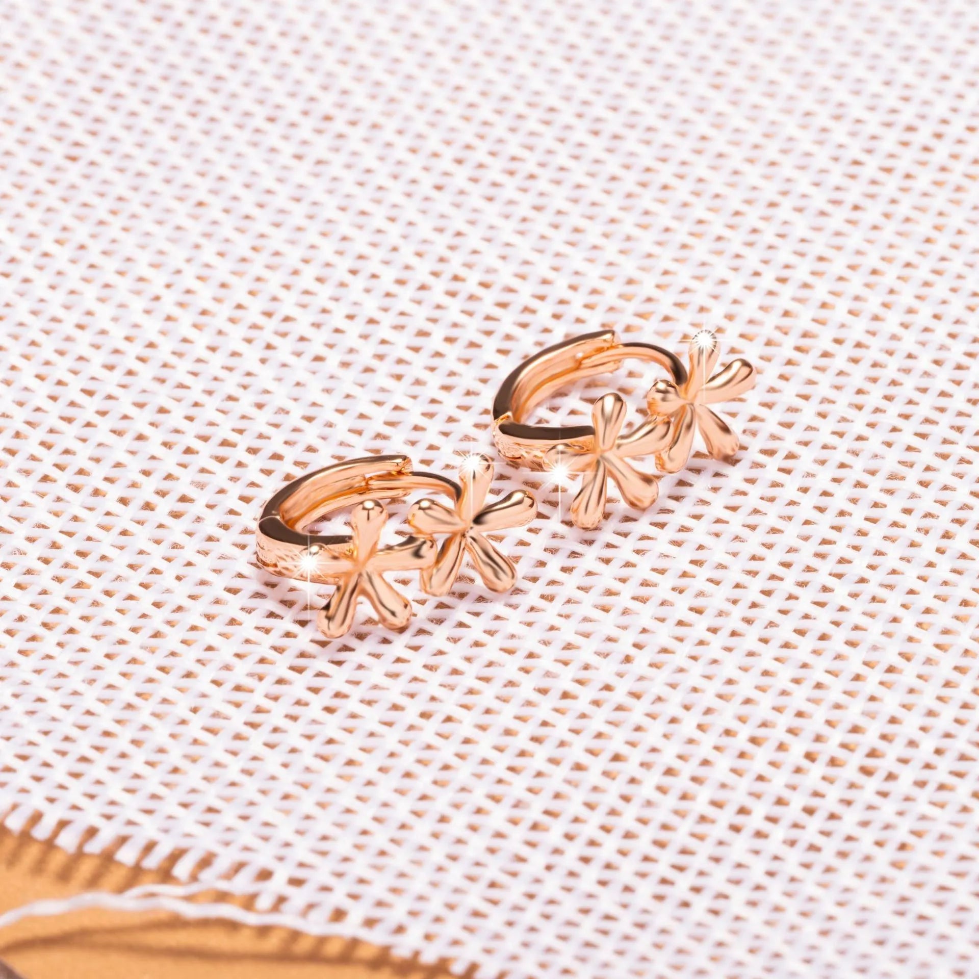 Circular rose gold electroplated earrings with a waterdrop floral design