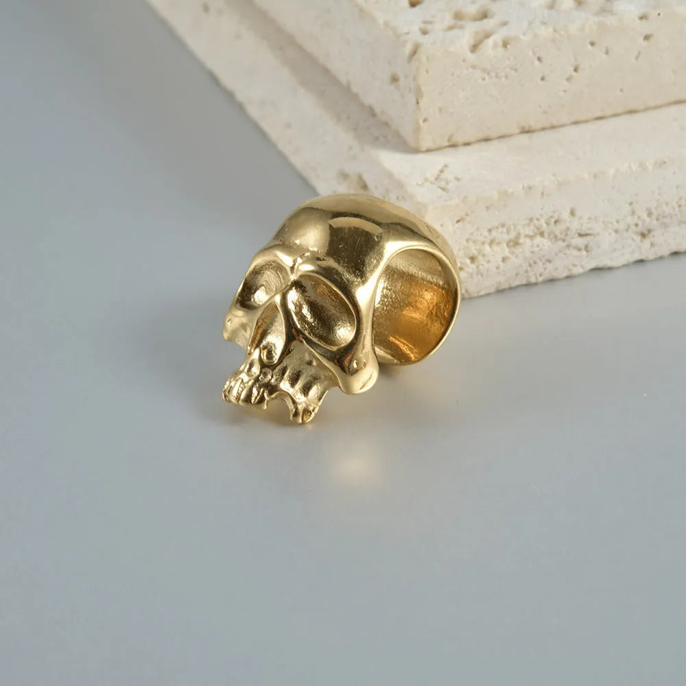 Stainless steel geometric earrings with hollow skull and Buddha head design in electroplated colour options.