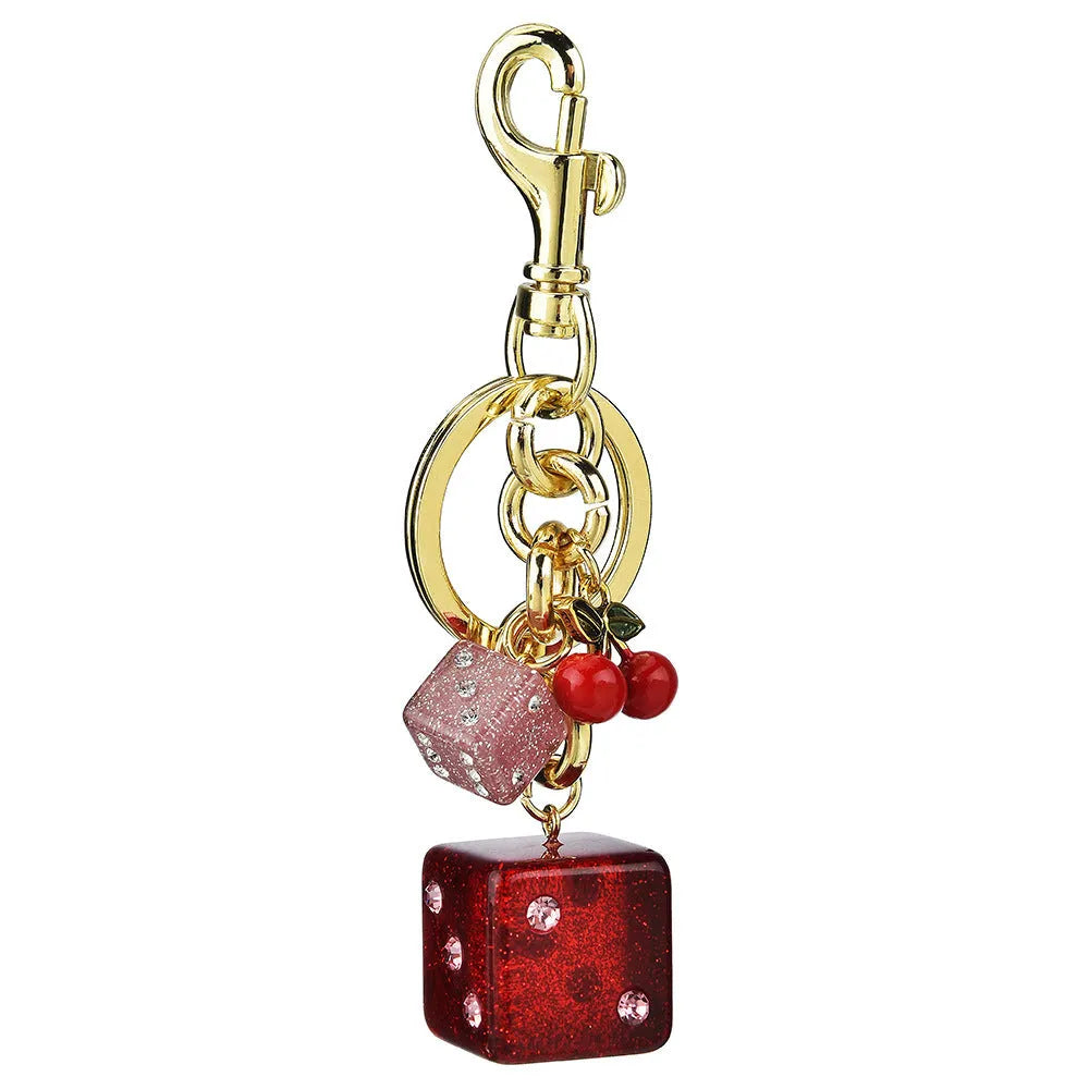 Vintage cherry red two-tone dice pendant on a metal keychain, a retro suitcase ornament.