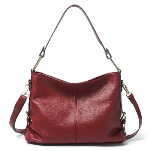 Genuine leather vertical square crossbody bag in black showing outer pocket and structured shape.