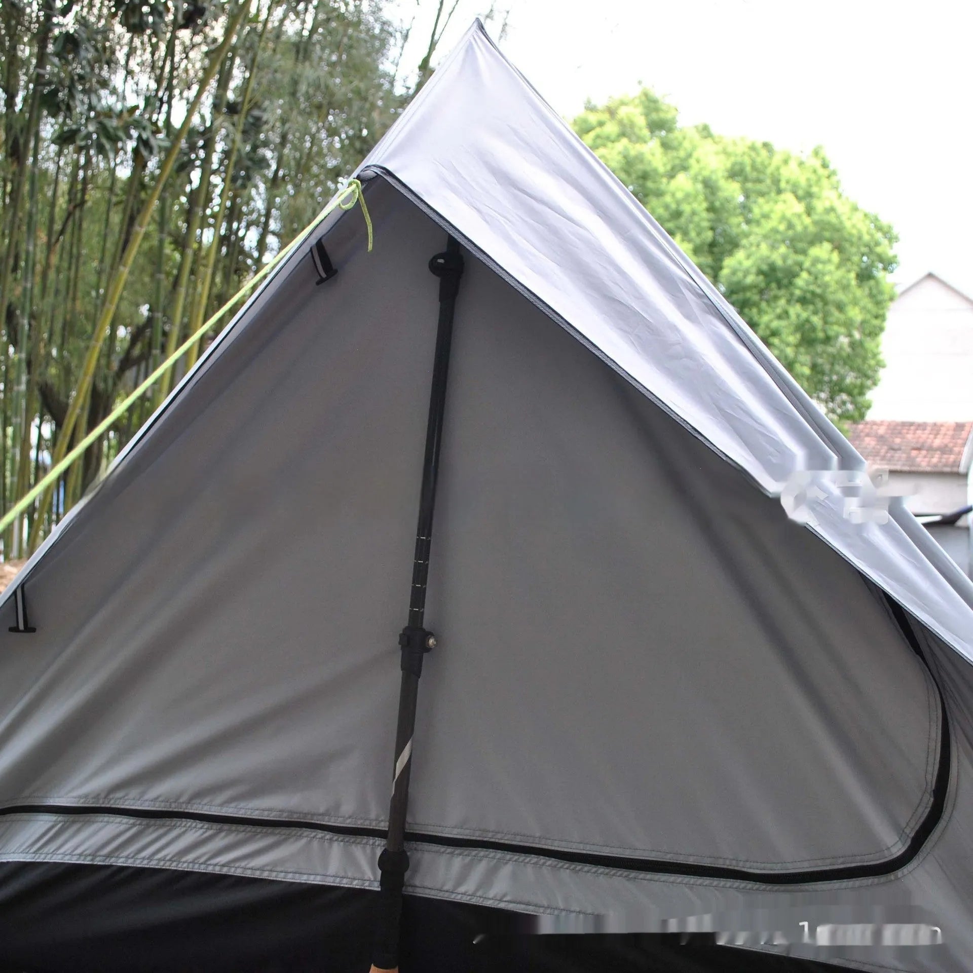 Brown or white A-line cabin tent pitched with trekking poles, showing spacious interior and waterproof fabric construction