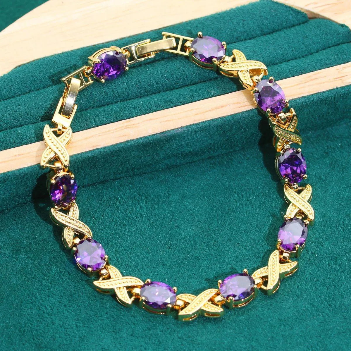 Gold coloured necklace, earrings, ring, and bracelet set with blue synthetic cubic zirconia stones.