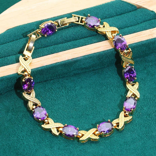 Gold coloured necklace, earrings, ring, and bracelet set with blue synthetic cubic zirconia stones.