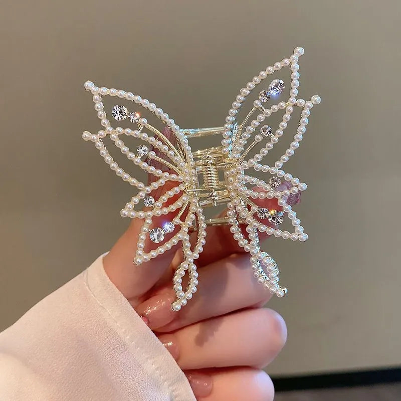 Elegant butterfly-shaped alloy hair clip for women, shown in rhinestone and pearl style options.