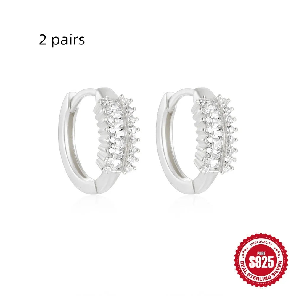 Sterling silver geometric stud earrings with a small round shape and classic diamond detail on a white background.