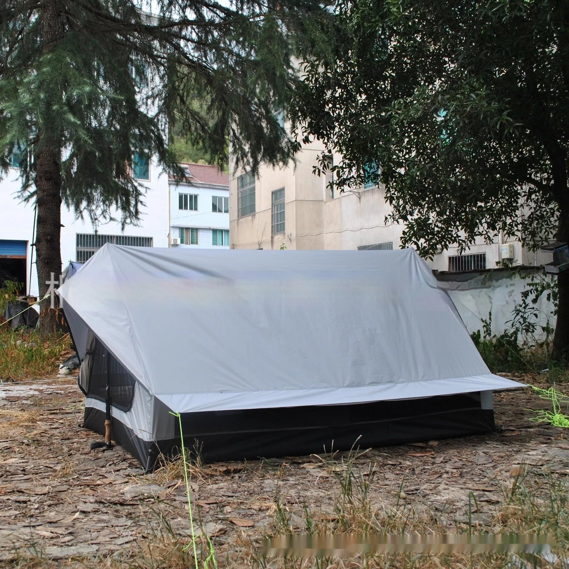 Brown or white A-line cabin tent pitched with trekking poles, showing spacious interior and waterproof fabric construction