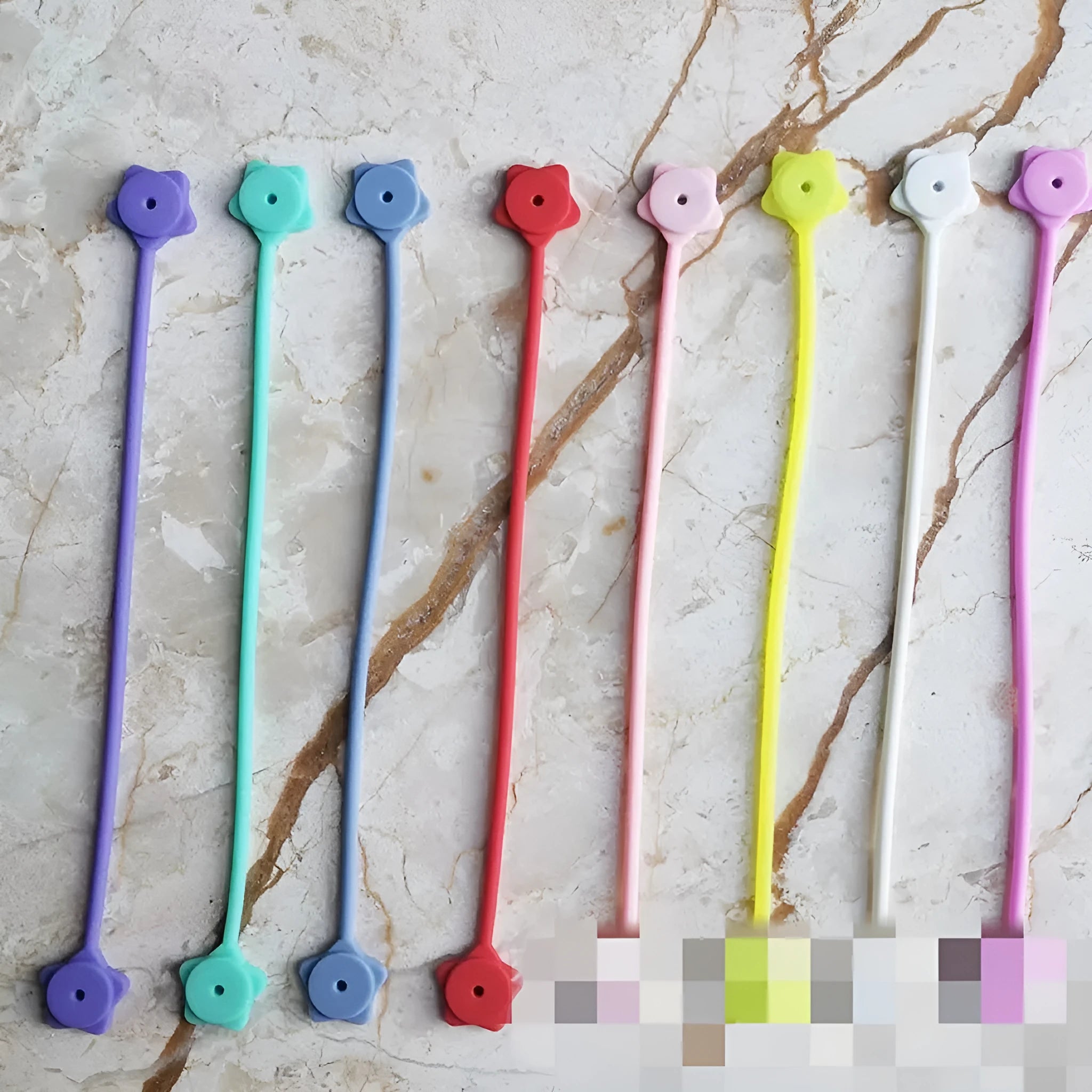 Purple silicone star-shaped cable winder with magnet, holding a coiled white USB cable.