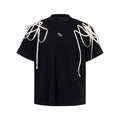 Black loose-fit short-sleeved T-shirt with a decorative rivet and ribbon padded shoulder detail.