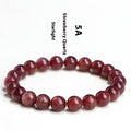 Natural cherry red strawberry quartz bracelet with geometry-shaped beads on a white background.