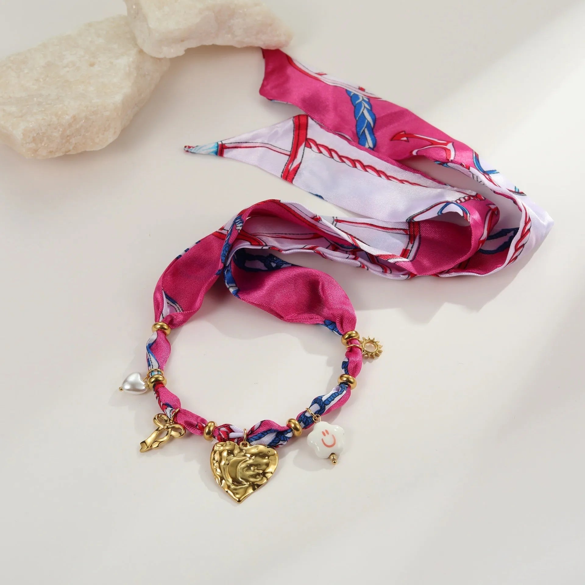 Gold-plated geometric love pendant necklace and matching bracelet jewellery set on display