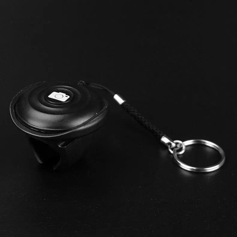 Black Bluetooth remote control for wireless smartphone camera photos and videos.