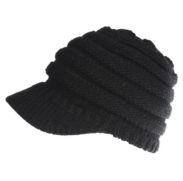 Woman wearing a soft knitted beanie with a ponytail pulled through the hole at the back.