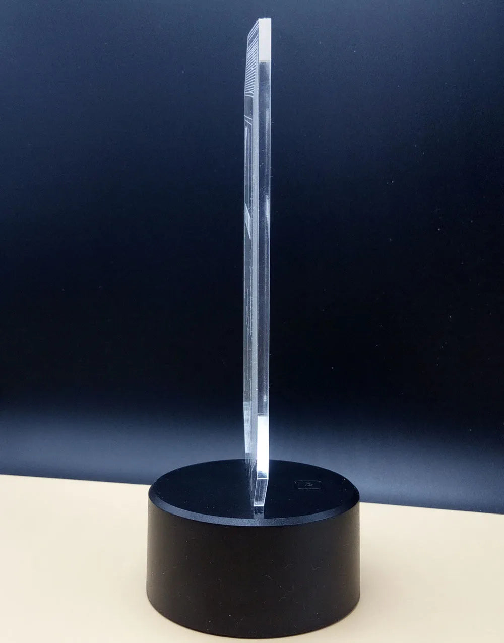 3D acrylic rose flower LED night light with remote control on a dark surface, showing colourful illumination.