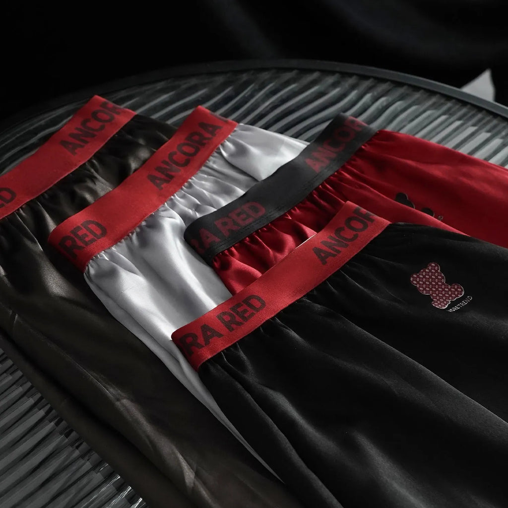 Men's solid colour boxer briefs in black, red, blue, silver, purple, and brown on a mid-waist fit.