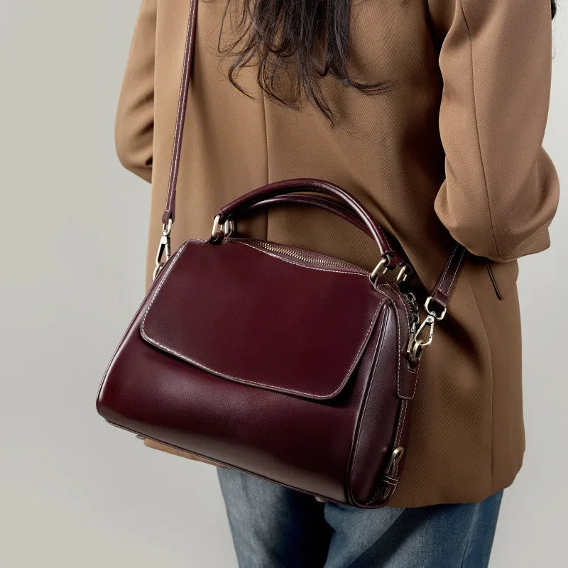 Women's genuine leather crossbody tote bag in apricot colour showing internal compartments and shoulder straps.