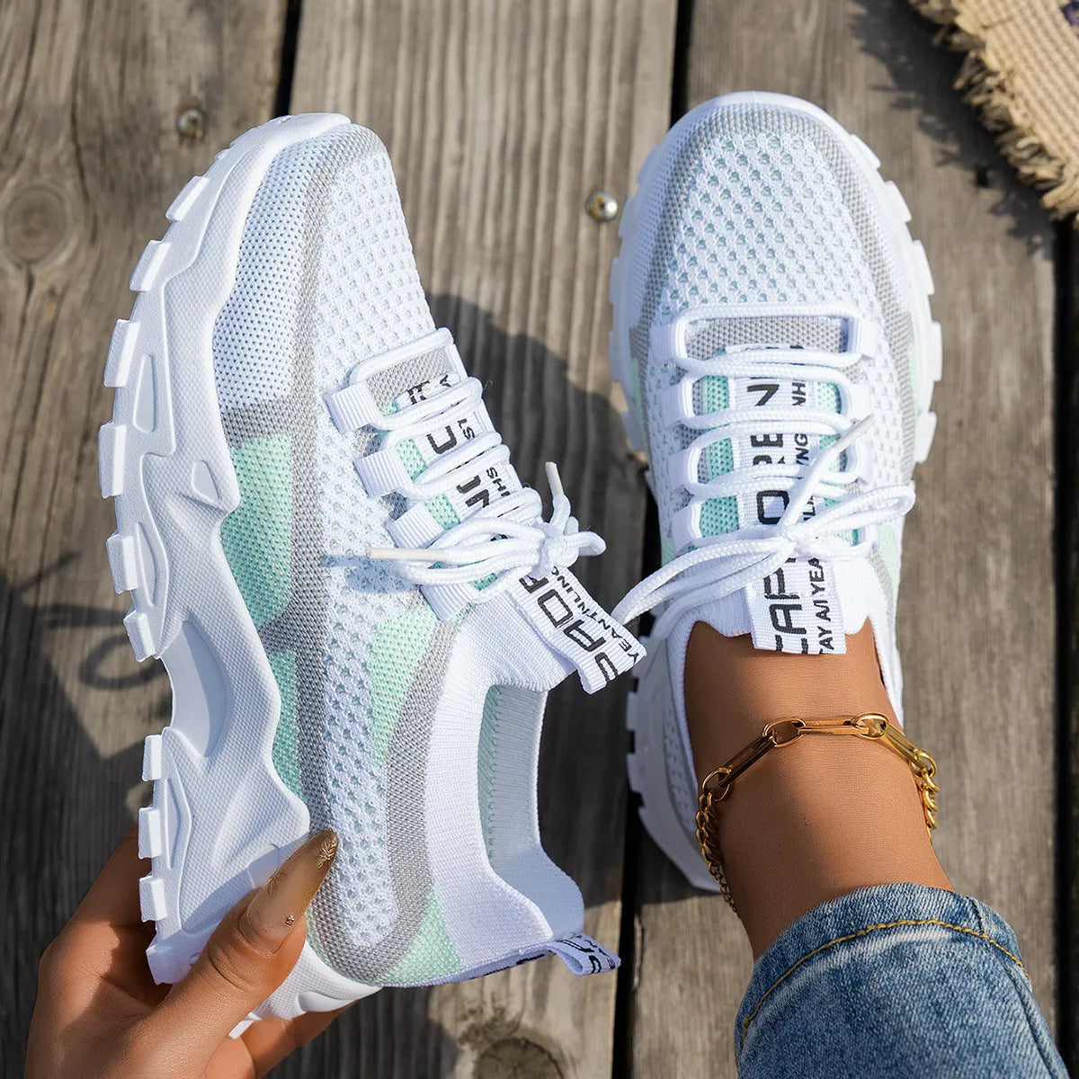 Women's Flyknit mesh lace-up sneakers in a grey colourway on a flat rubber sole.