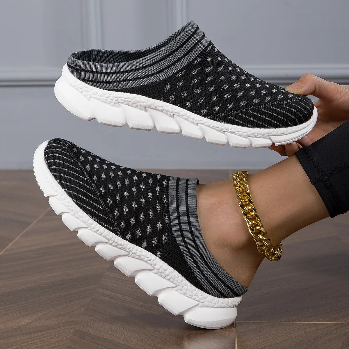 Women's black Flyknit slipper shoes with striped pattern and hollowed-out design on a viscose sole.